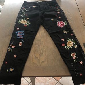 Black jeans adorned with flowers and studs